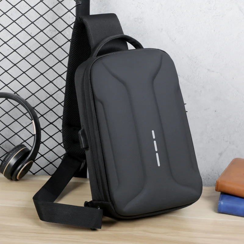 Black hardshell anti-theft crossbody bag with a single strap, built-in USB charging port and minimalist design.