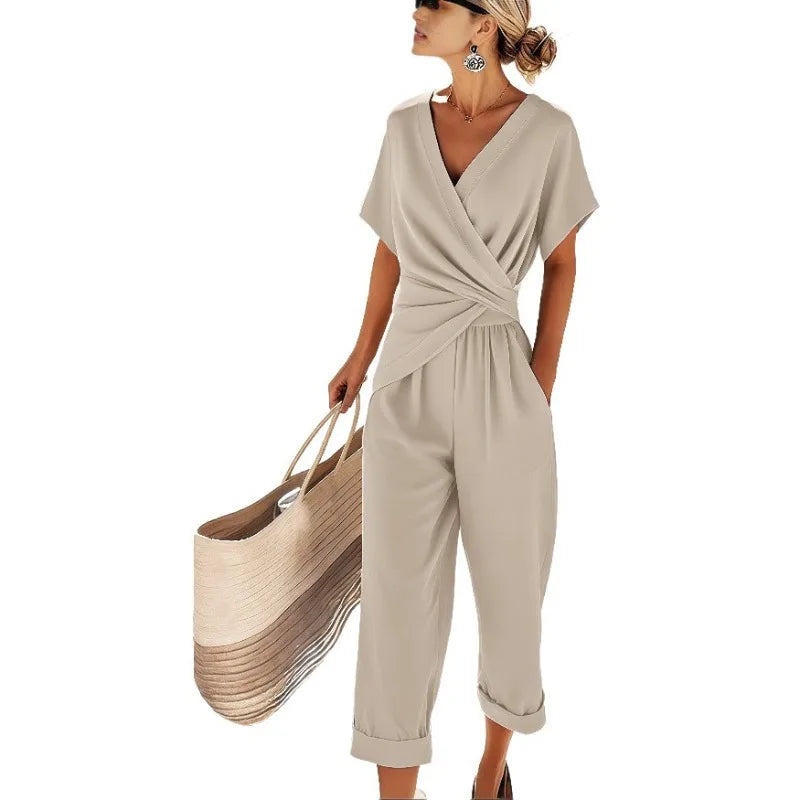 Beige wrap-front jumpsuit with short sleeves, V-neck, cinched waist, and cropped straight legs with turned-up cuffs.