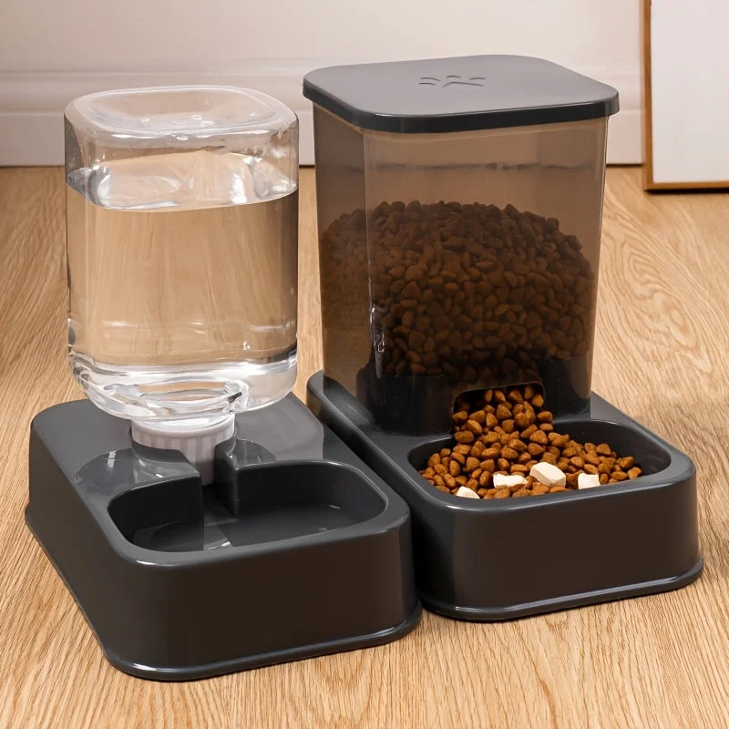 Grey automatic pet water and food dispenser set with transparent containers, set on a wooden floor.