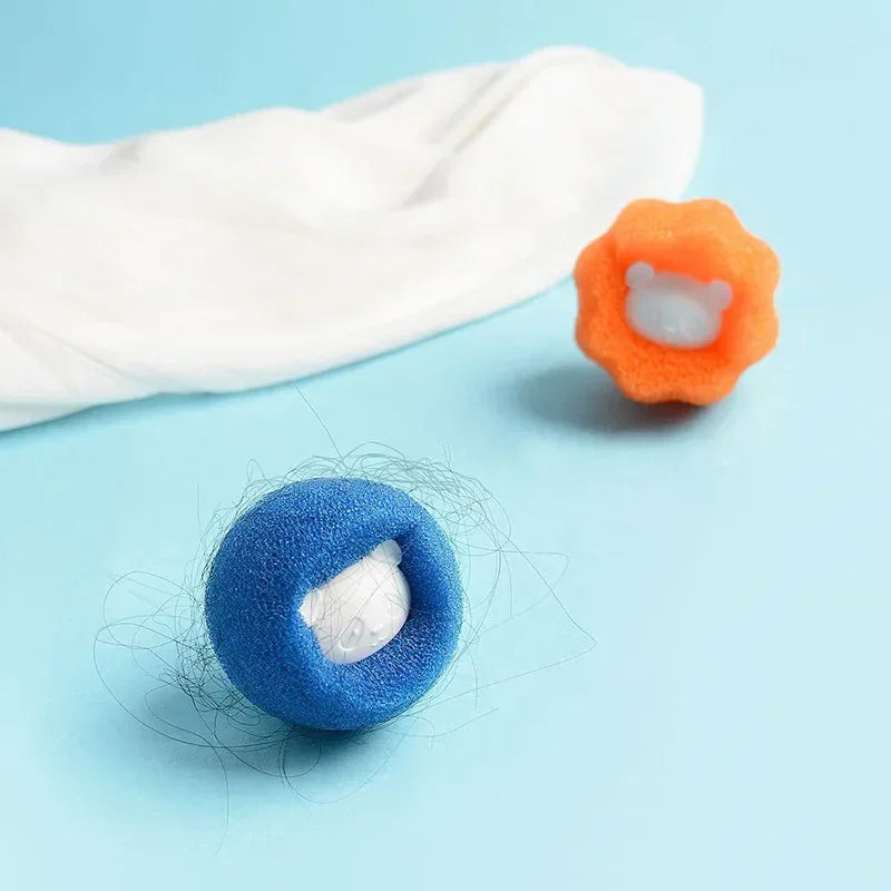 Blue and orange foam laundry hair catcher balls with a cute bear centre, shown collecting hair on a blue background.