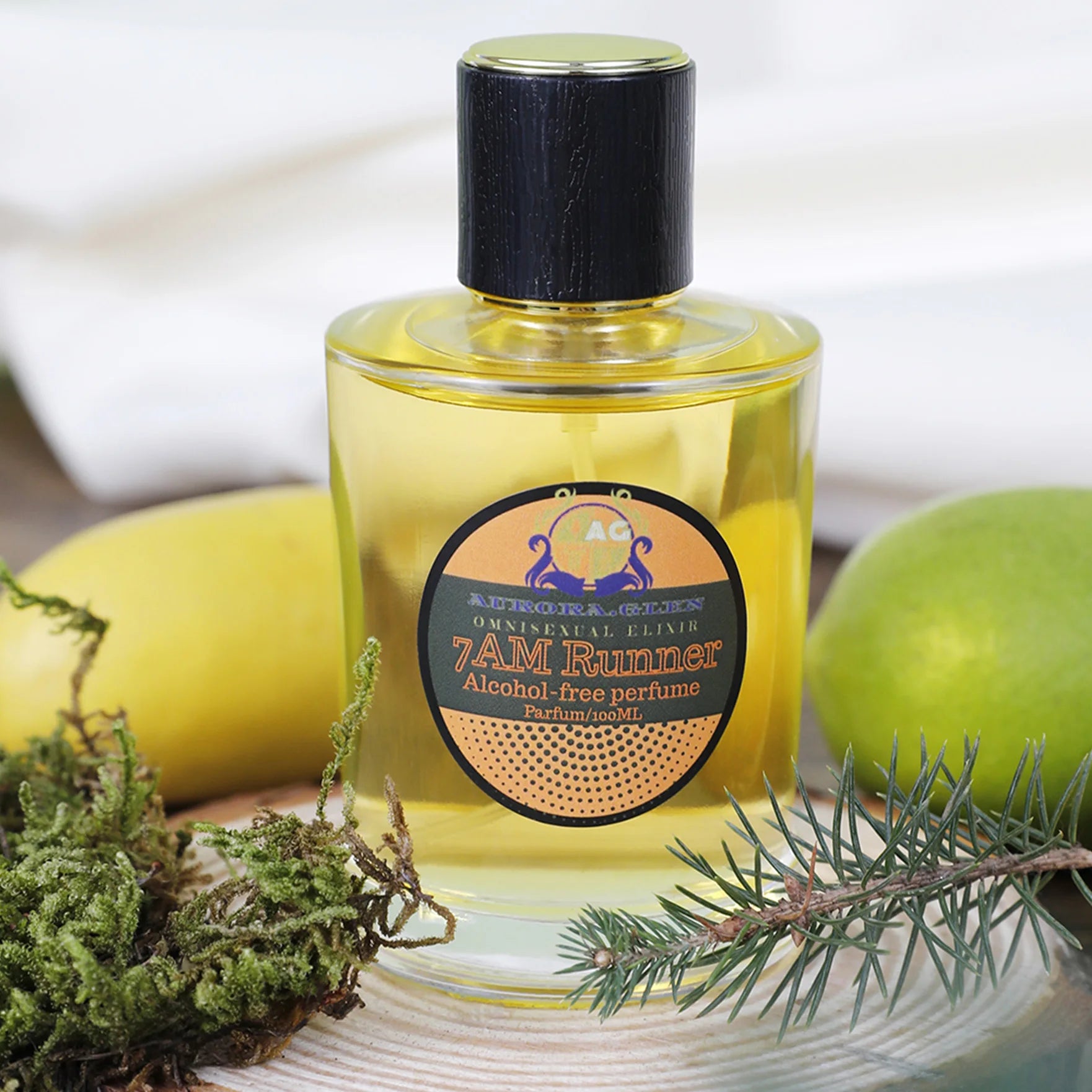 100ml bottle of yellow alcohol-free perfume with a black cap, displayed with fresh lime, lemon, and pine on wood.