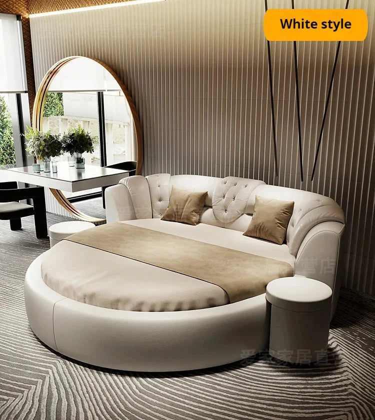 Modern white circular double bed with tufted headboard, tan cushions and matching side stool in a luxury bedroom.