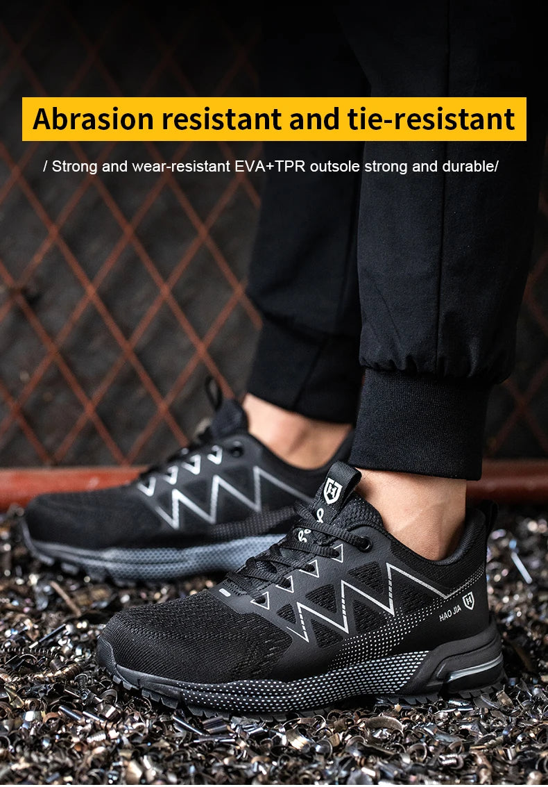Black safety work sneakers with steel toes, lace-up front, patterned soles, and reflective zigzag side details.