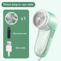 Mint green fabric shaver with USB cable, cleaning brush, and blade attachment, for removing lint from clothes.