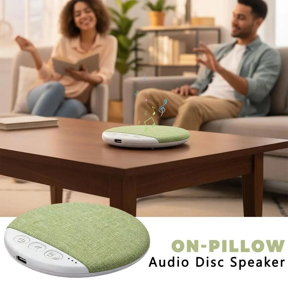 Round, green, fabric-covered wireless under-pillow speaker with white trim and easy-to-use button controls.