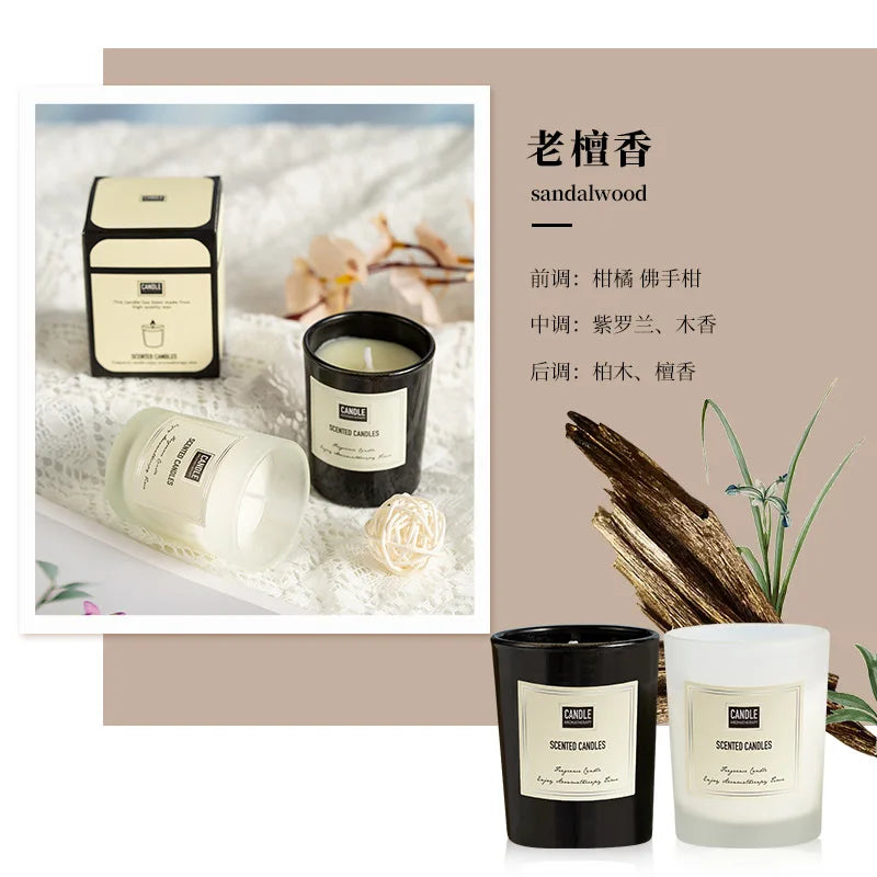 Two luxury scented candles in black and frosted white glass jars with minimalist labels on a lace background.