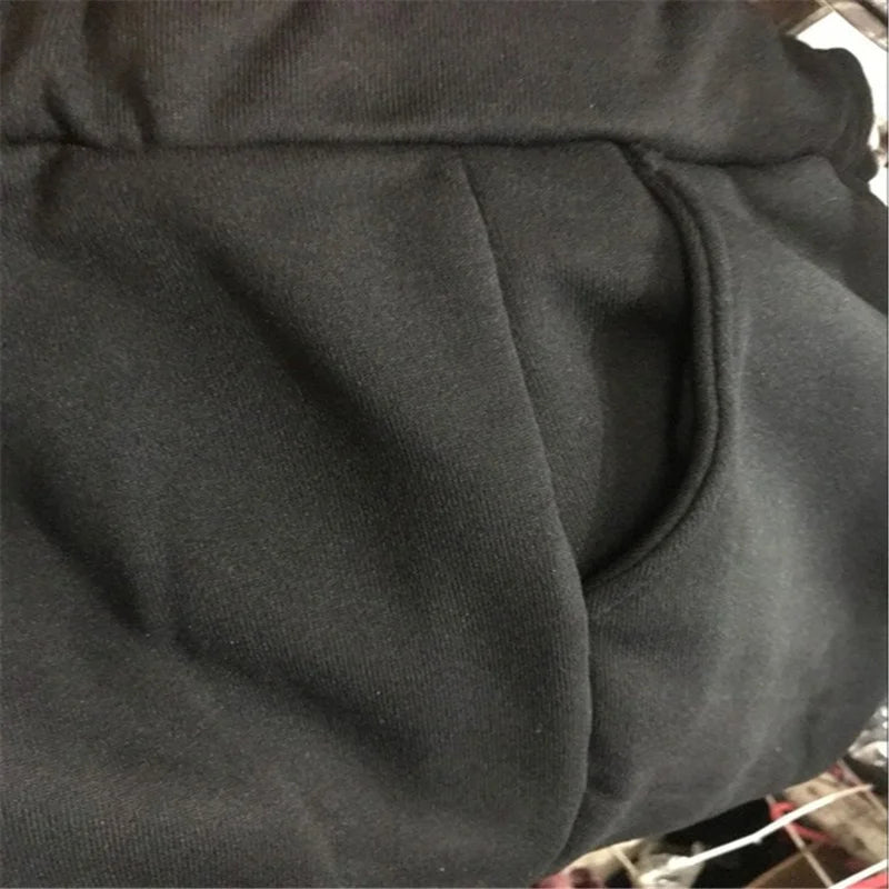 Close-up of black fleece-lined sweatpants featuring a comfortable elasticated waistband and a side pocket.