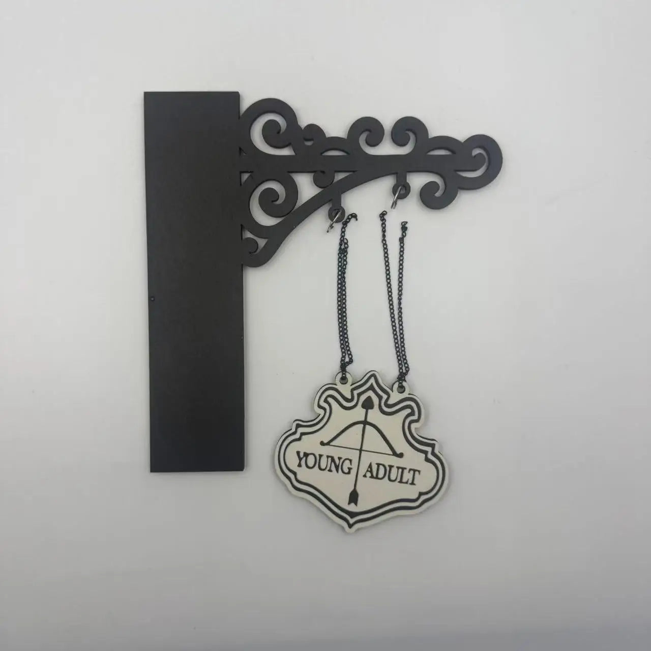 Decorative black wall bracket holding a cream-coloured hanging sign that reads 'YOUNG ADULT' with an arrow icon.