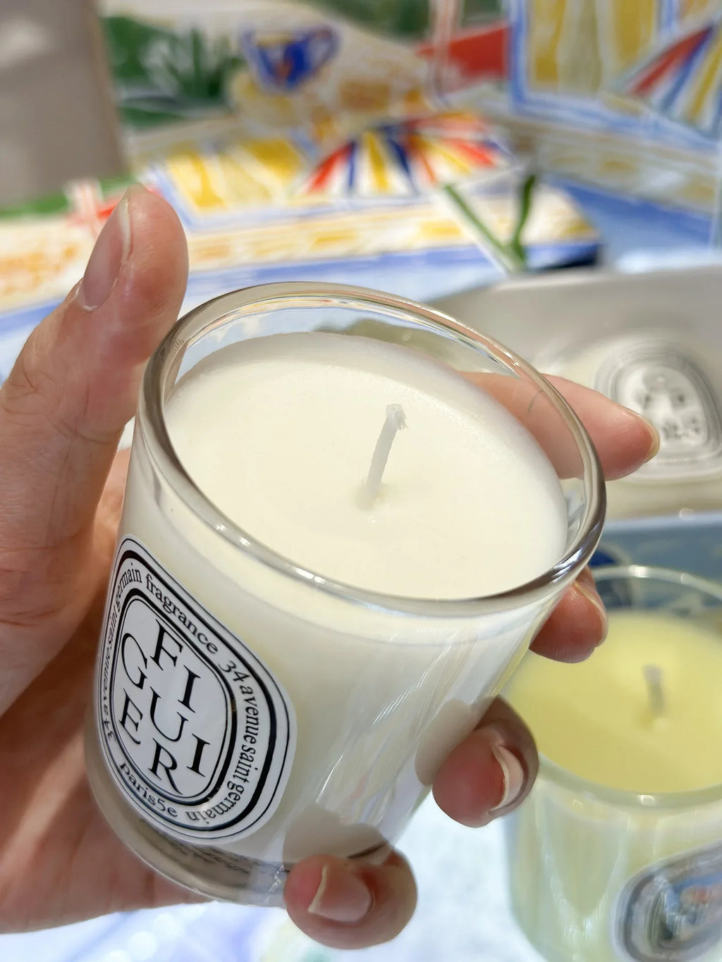 Small, white scented candle in a clear glass votive with a minimalist black and white circular label.