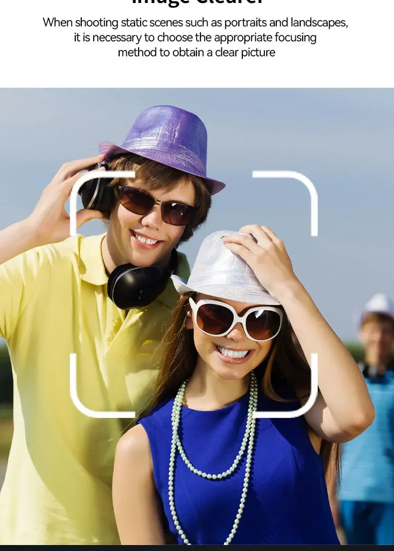 A man in a purple hat and yellow polo and a woman in a silver hat and blue dress, with a focus frame overlay.