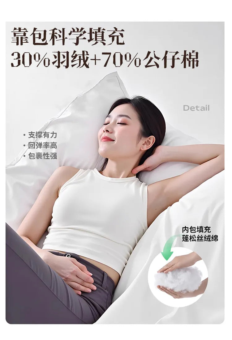 A woman relaxing against a plush, cream-coloured upholstered headboard with a focus on its soft, supportive filling.