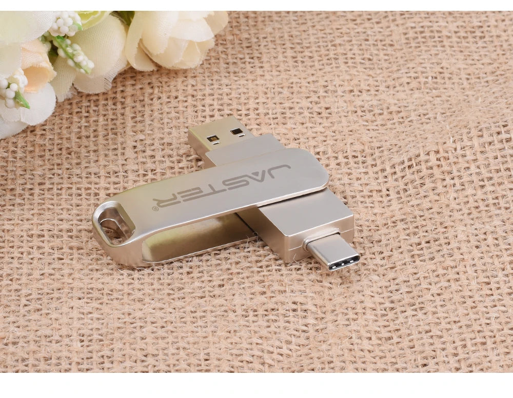 Sleek, silver metal 2-in-1 dual USB-C and USB 2.0 flash drive on a textured beige background.