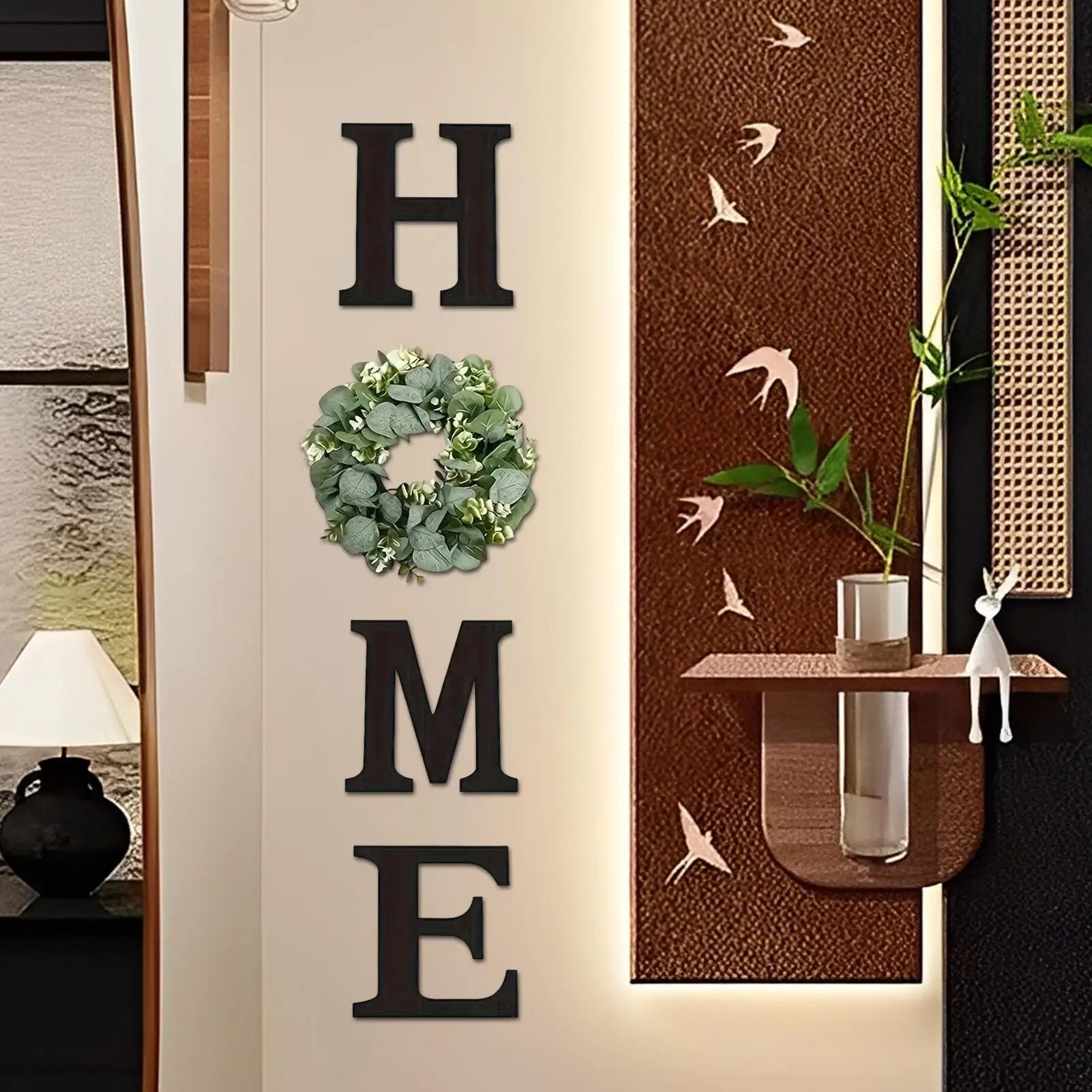 Rustic black wooden "HOME" wall sign featuring a lush artificial eucalyptus wreath replacing the letter O.