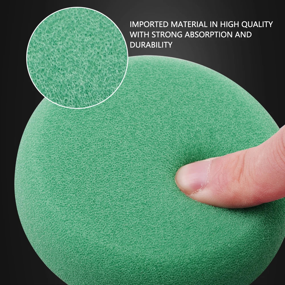A green round mini polishing sponge pad with a textured, porous foam surface being compressed by a finger.