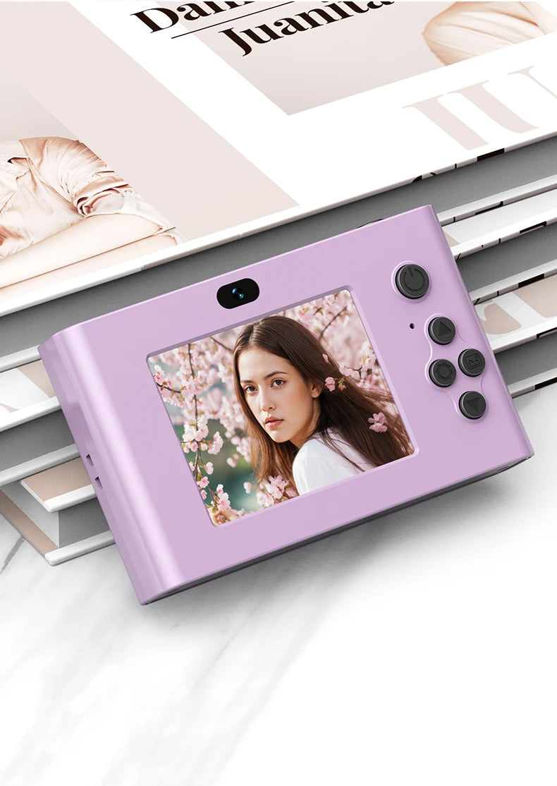 Light purple plastic digital instant camera with a rear screen displaying a woman, power button, and control buttons.