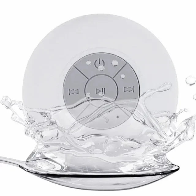 White circular waterproof Bluetooth speaker with a suction cup back and central media control buttons, splashing water.