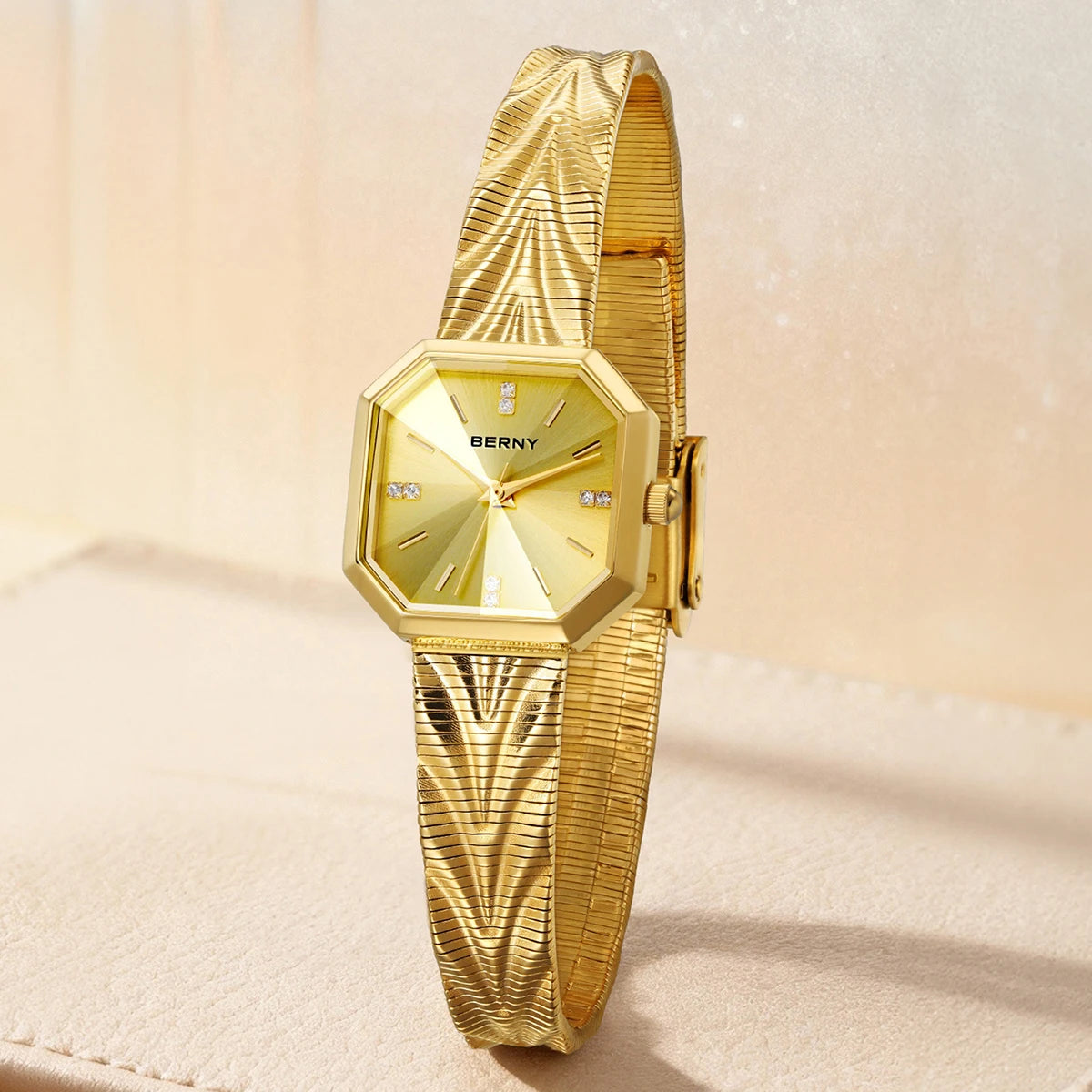 BERNY gold women's watch with an octagonal case, sunburst dial, and textured mesh stainless steel band.
