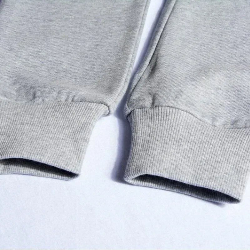 Close-up of light grey jersey joggers featuring comfortable elasticated ribbed cuffs at the ankles.