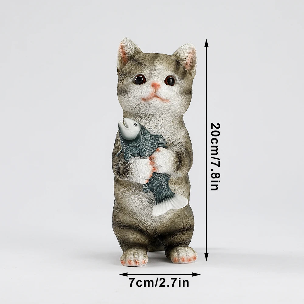 A charming grey tabby resin kitten garden statue standing and holding a fish. Measures 20cm high.