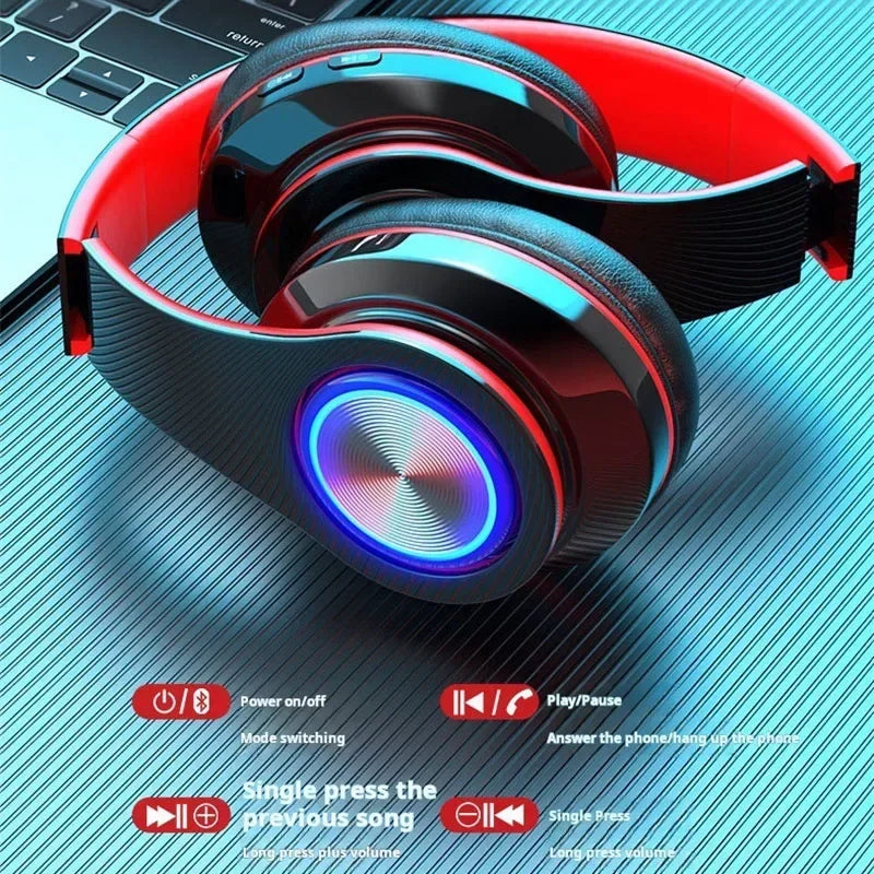 Black and red wireless gaming headset with glowing blue circular LED earcups, resting on a textured metallic surface.