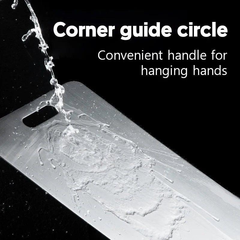 Water is poured onto a metal cutting board with a handle slot, set against a dark background.