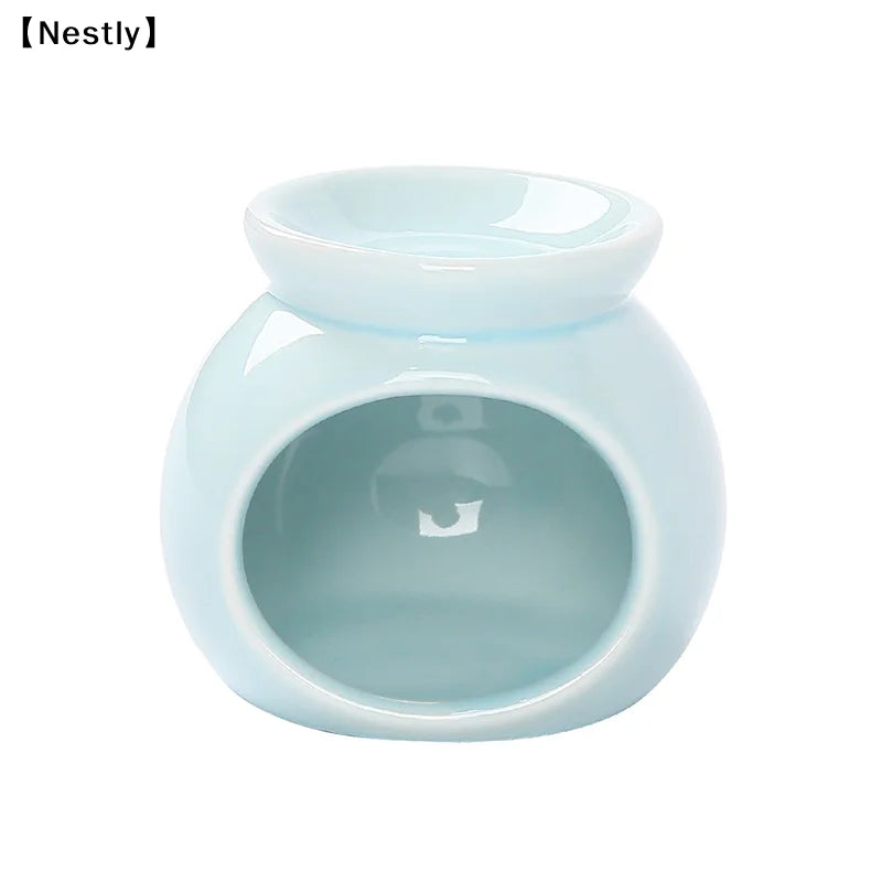 Glossy, light blue ceramic oil burner with a round, bulbous design and top dish for wax melts.