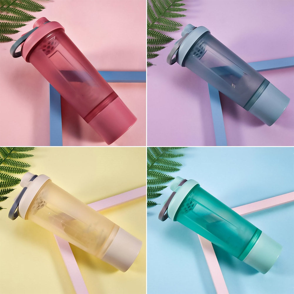Four translucent, multi-compartment shaker bottles in pink, blue, beige, and green with carrying handles.