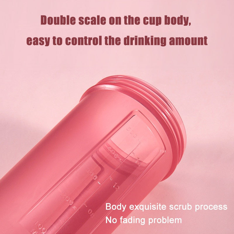Pink plastic shaker cup with a textured scrub finish and dual measurement scales on the side.
