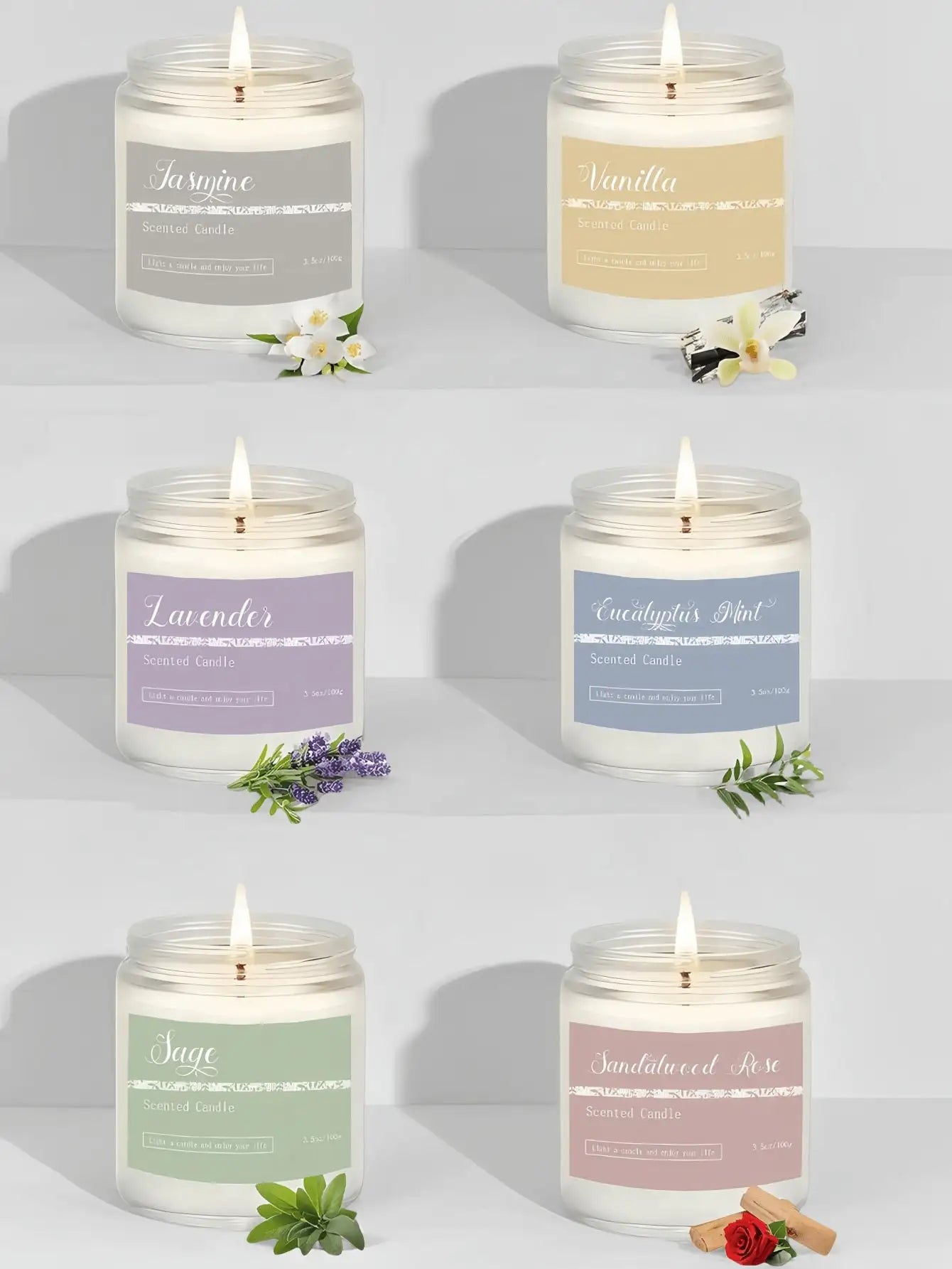 Six scented candles in glass jars with pastel labels and botanical accents, each with a lit wick.