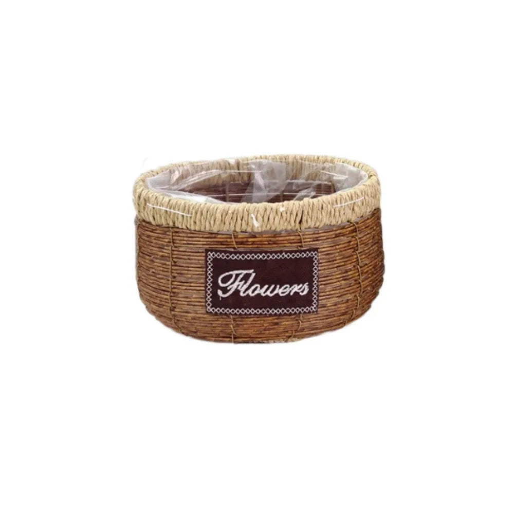Round rustic brown woven basket with a light beige rim, clear inner liner, and a "Flowers" label on the front.