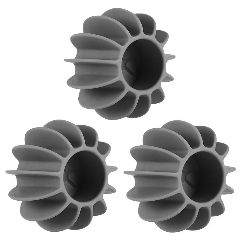 Three grey silicone laundry dryer balls with a ribbed, spoked, flower-like design.