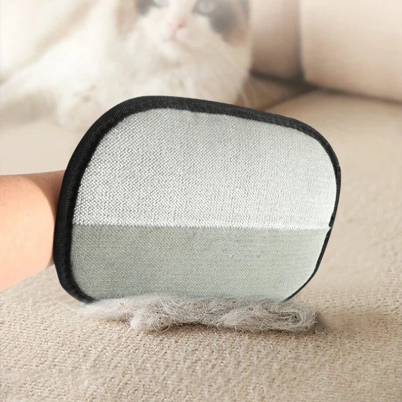 Grey and white pet hair removal glove being used to collect lint from a fabric sofa.