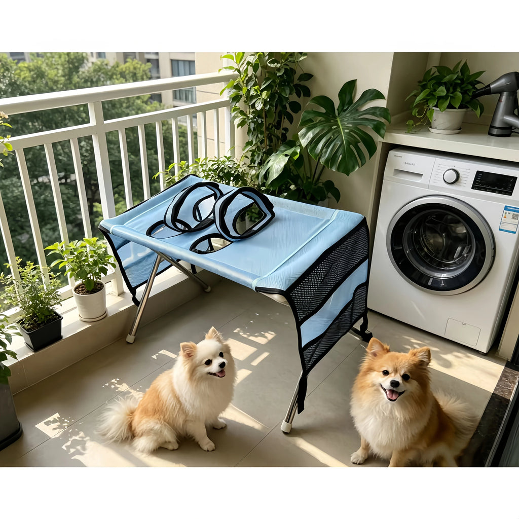 Light blue foldable pet grooming table with metal legs, mesh sides, and hanging support harness.