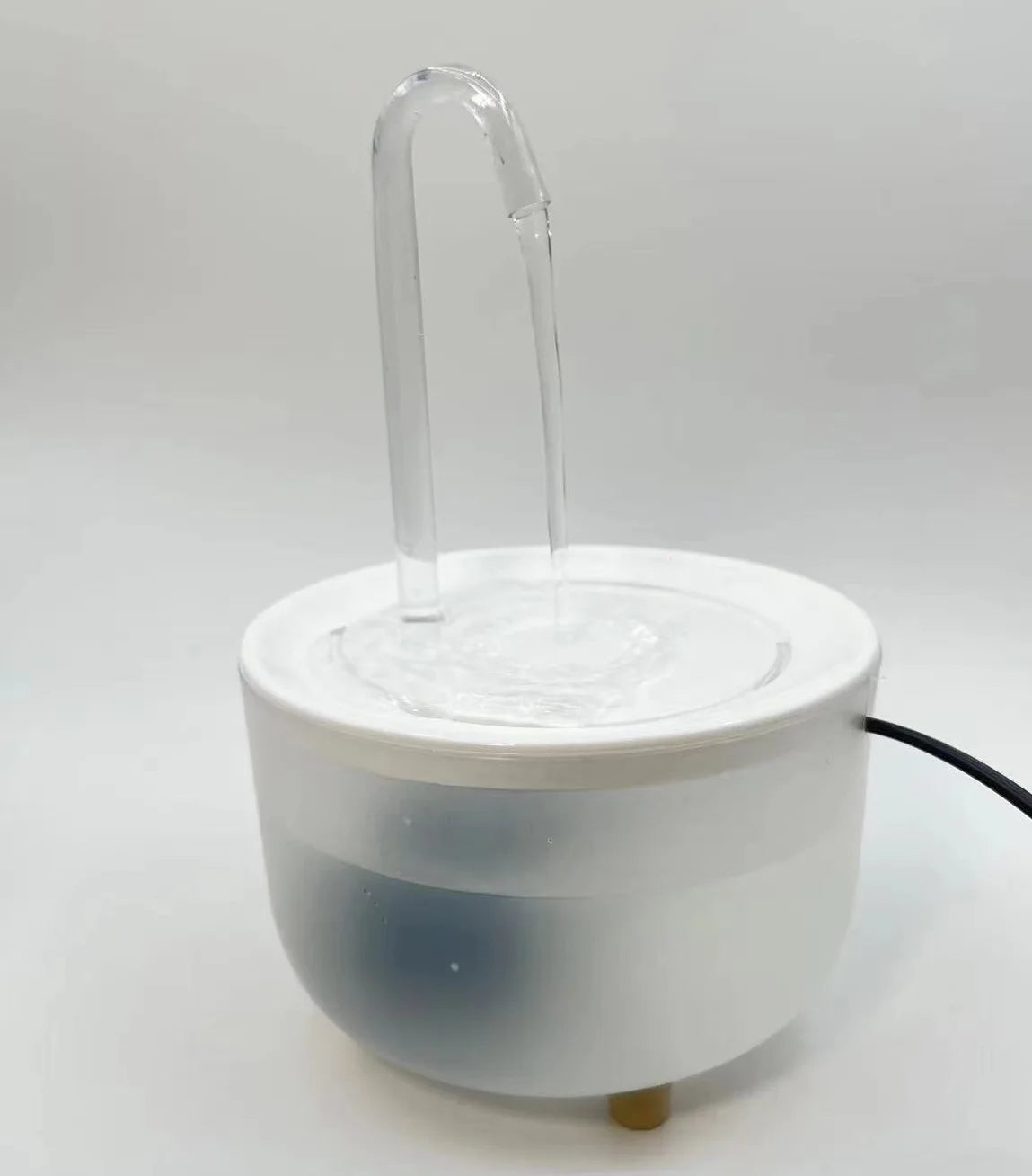 White pet water fountain with a clear, curved spout and flowing water against a plain background.