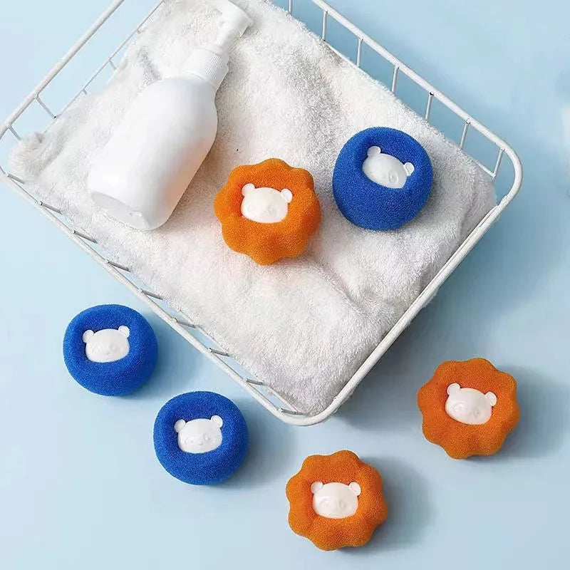 Blue and orange bear-shaped sponges for cleaning in a wire basket with a white towel and pump bottle.