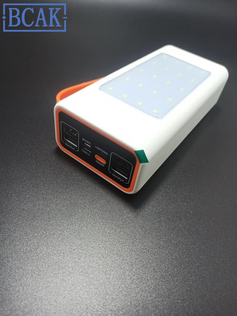 White and orange portable power bank featuring multiple USB ports and a built-in LED light panel.