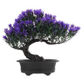 Artificial purple flower bonsai tree in a black oval pot against a white background.