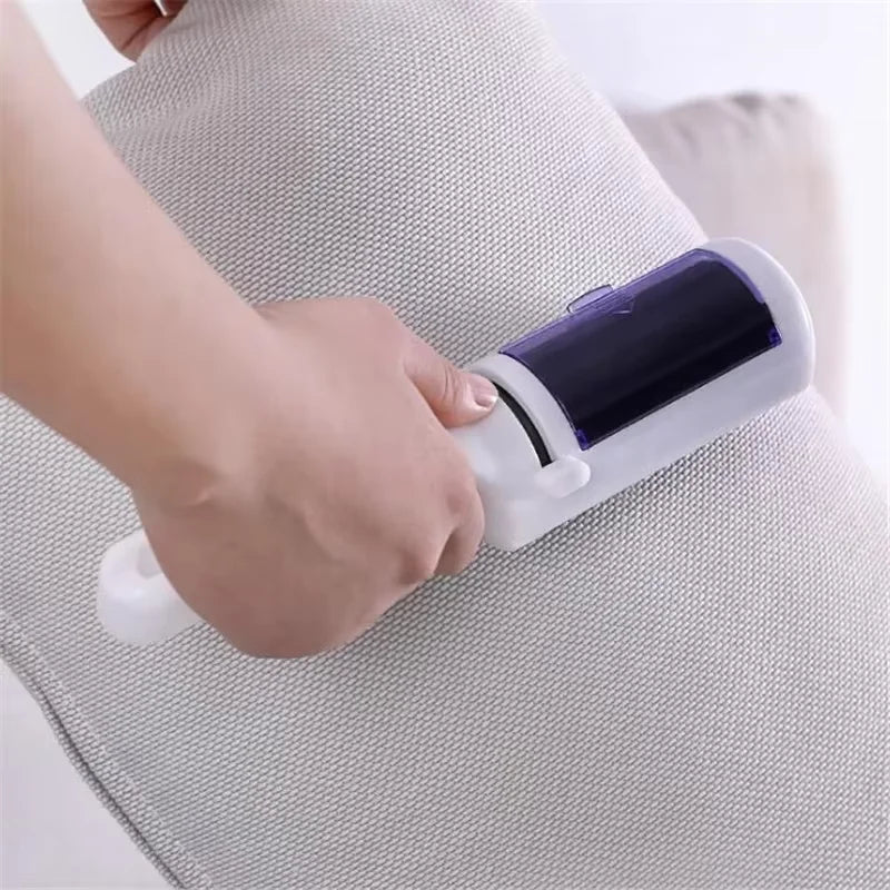 White and purple handheld lint remover being used to clean a light grey fabric cushion.