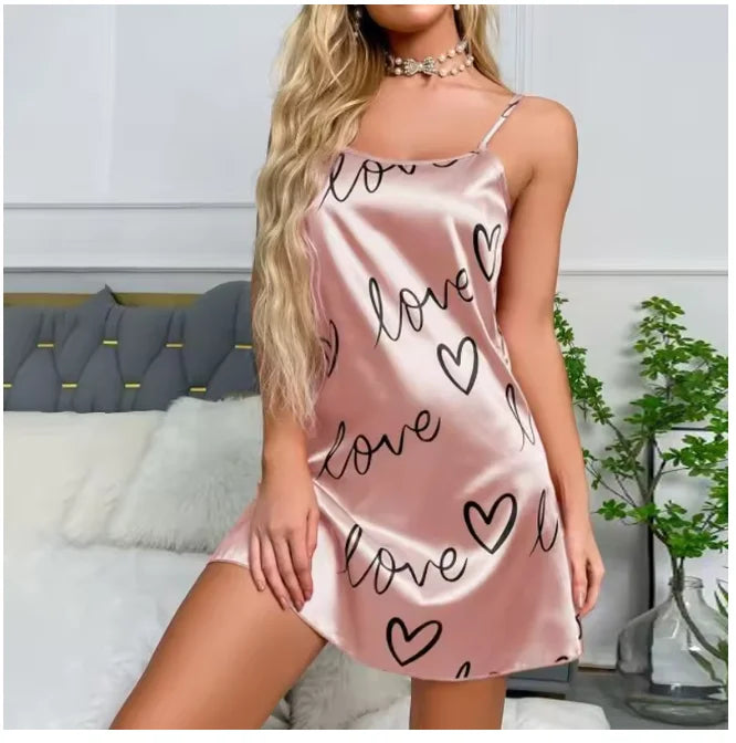 Pink satin camisole nightdress with black ‘love’ and heart print, featuring delicate spaghetti straps.