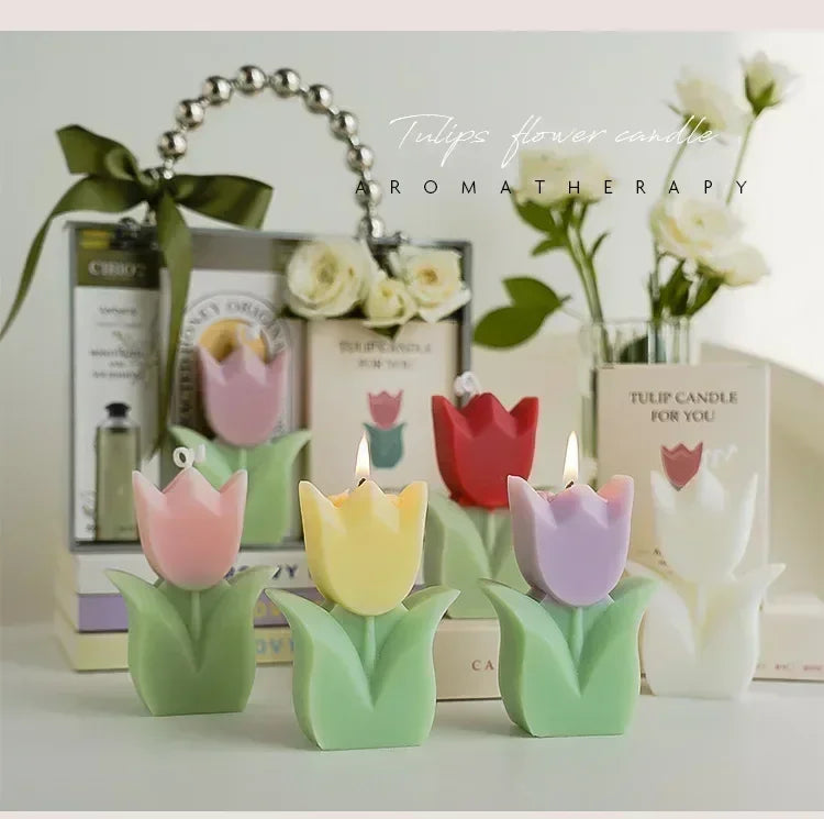 Pastel-coloured tulip-shaped aromatherapy candles in pink, yellow, red, purple, and white with green leaves.