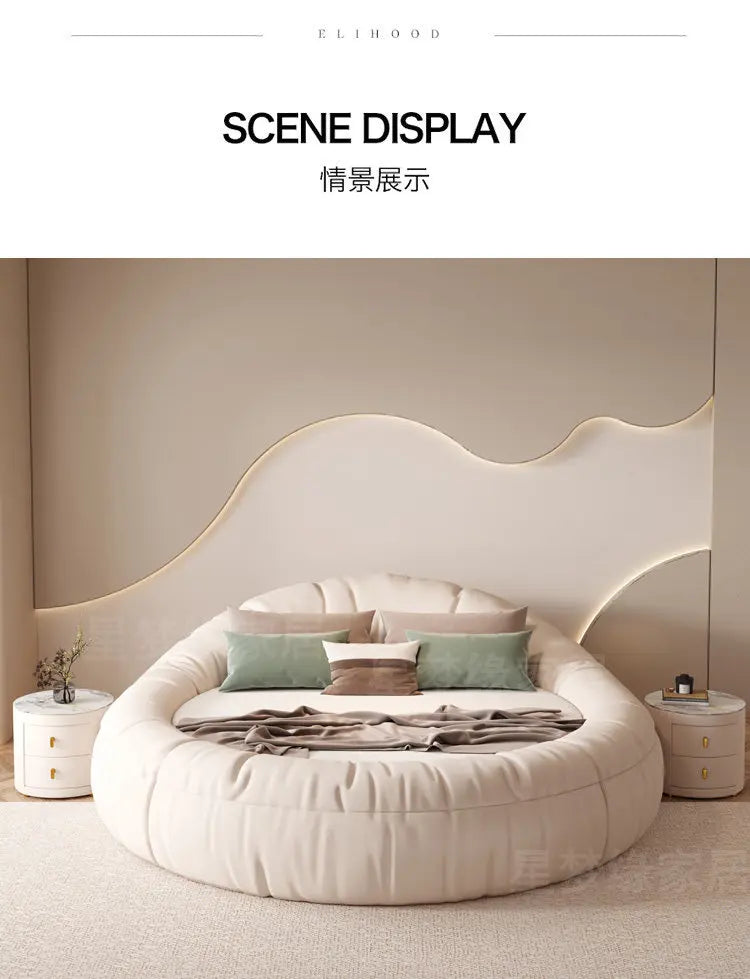 Modern, circular cream-coloured upholstered bed frame in a minimalist bedroom setting.