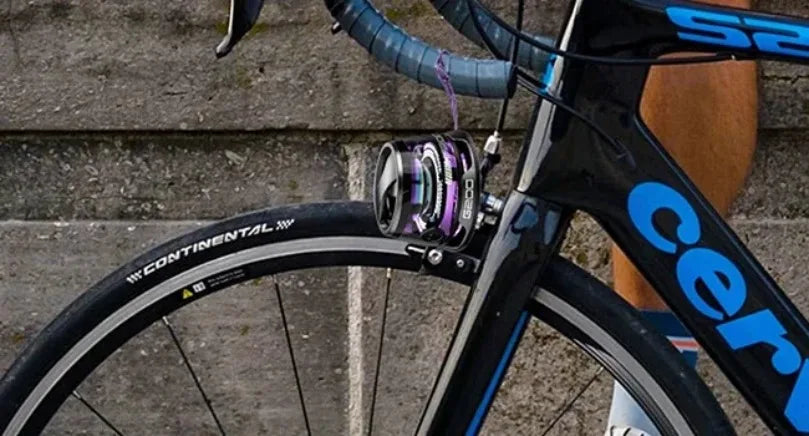 Compact, purple-accented Bluetooth speaker with RGB lighting mounted to the handlebars of a racing bicycle.