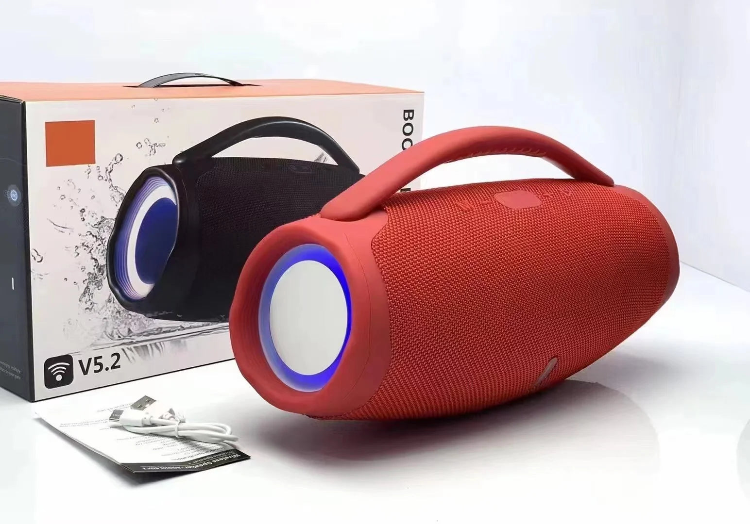 A red portable waterproof Bluetooth speaker with glowing RGB light rings, next to its retail packaging and a charging cable.