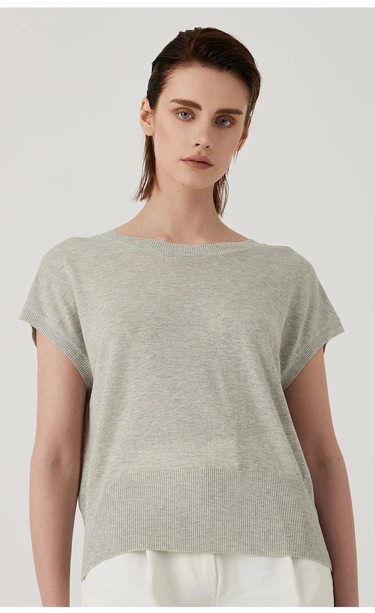 Model wearing a light grey, lightweight knit top with a crew neck, short sleeves, and a ribbed hem.