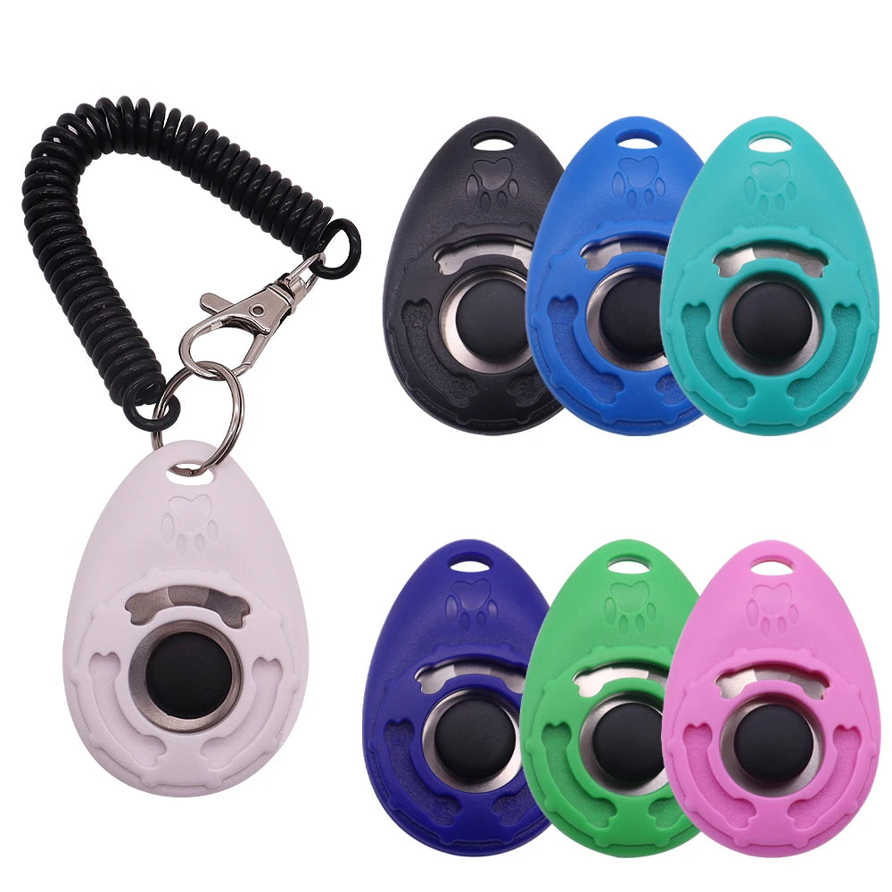 A set of colourful, teardrop-shaped dog training clickers with central buttons, keyrings and coiled wrist straps.