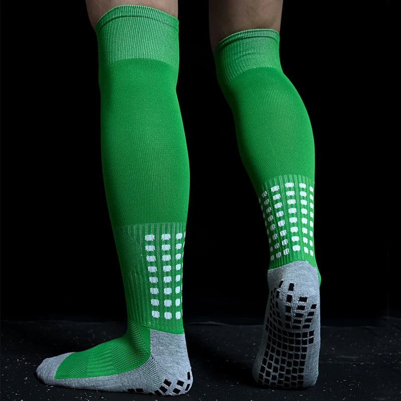 Bright green over-the-calf sports socks with white grid detailing and grey non-slip grip soles.