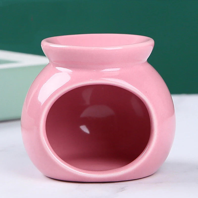 Glossy, round pink ceramic wax melt warmer with an open front for a tea light candle.