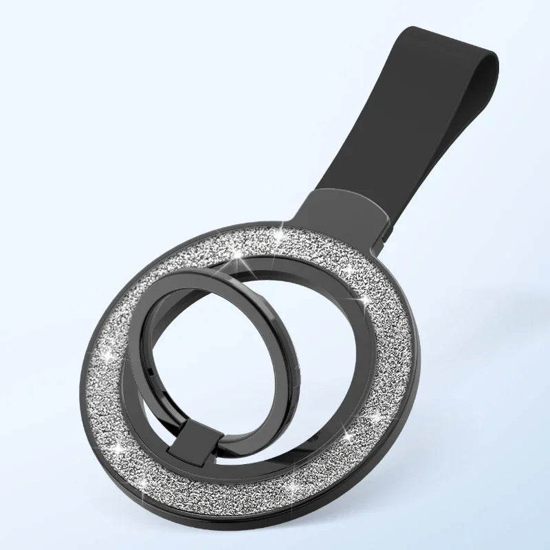 Black phone ring holder with a circular base featuring a sparkling silver glitter inlay and a sturdy wrist strap.