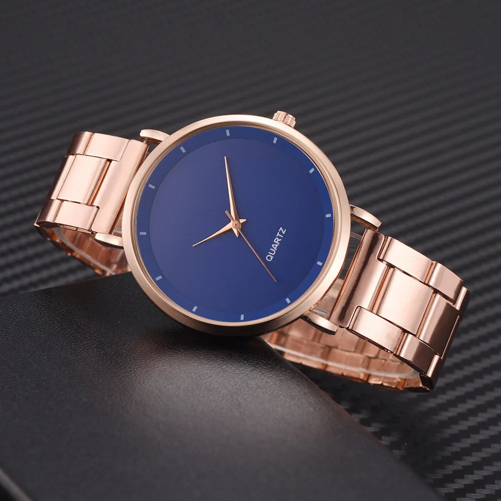Ladies' rose gold stainless steel watch with a minimalist blue round face and slim metallic hands.