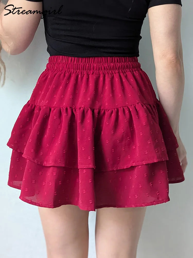 Red tiered mini skirt with an elastic waistband and textured dots, paired with a black top.